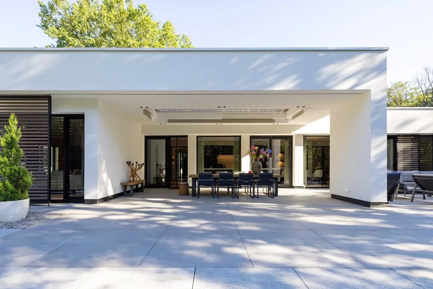 Vooraanzicht van de villa met carport in de avond
