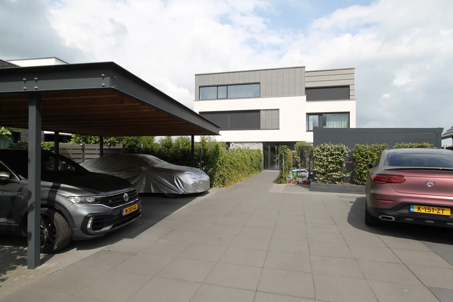 De woning met overdekte carport en oprit